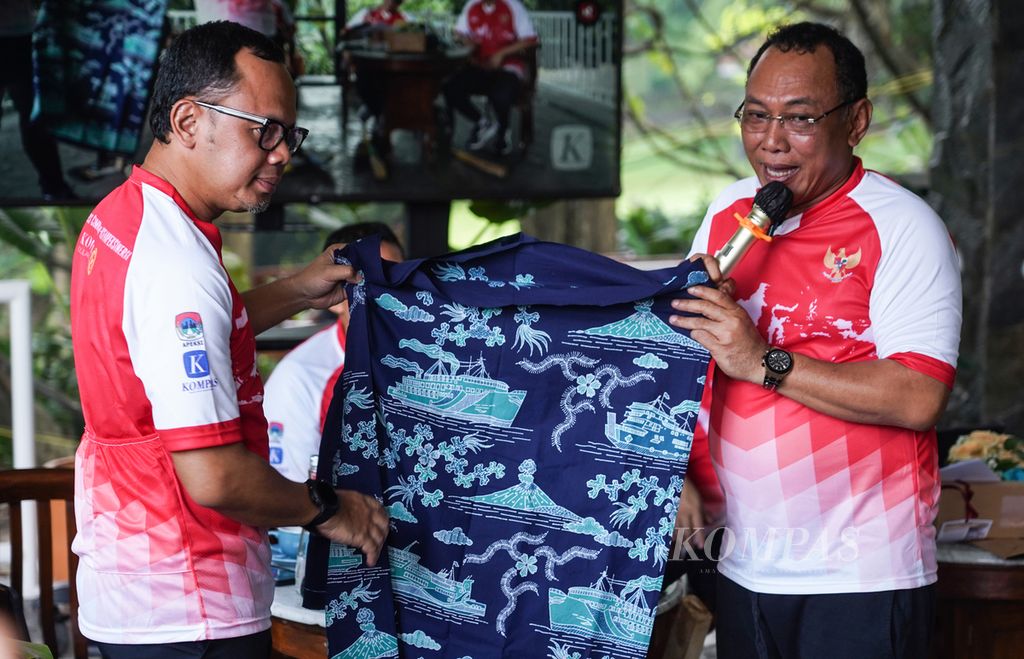 Cilegon Mayor Helldy Agustian (right) hands over a typical Cilegon batik to the Chairman of APEKSI Bima Arya Sugiartoy at the Bogor Botanical Gardens, Bogor City, West Java, on Saturday (3/9/2022).