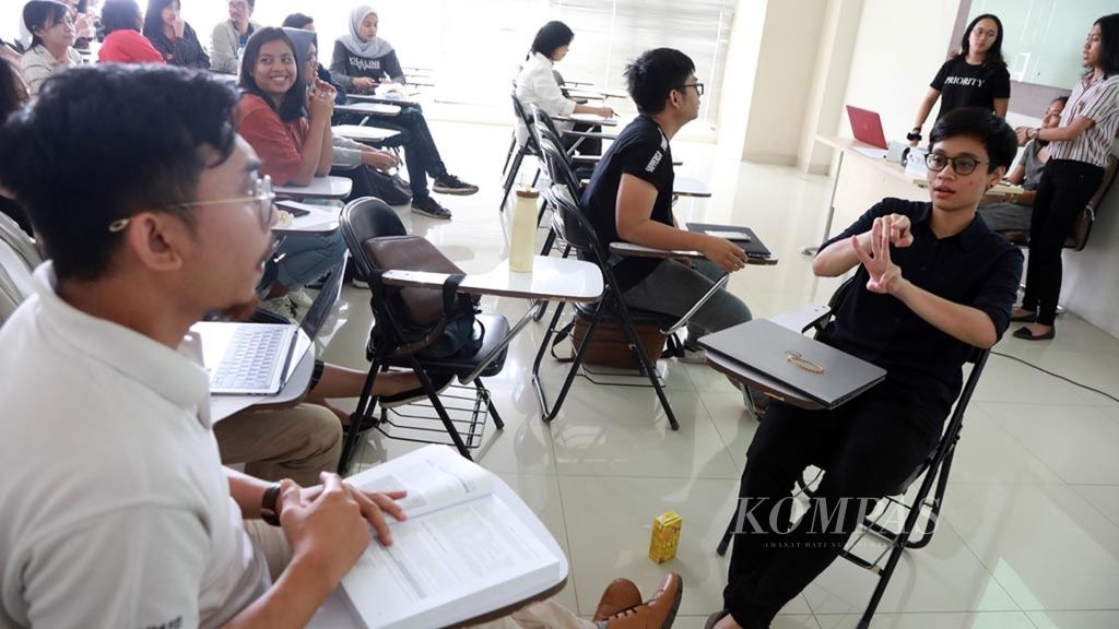 Pendampingan Mahasiswa DifabelJuru Bahasa (kanan) menerjemahkan materi kuliah ke bahasa isyarat mendampingi mahasiswa berkebutuhan khusus (kiri) di ruang kuliah kampus Fakultas Ilmu Bahasa Jurusan Sastra Inggris Universitas Indonesia, Depok, Jawa Barat, Senin (22/10/2018). 