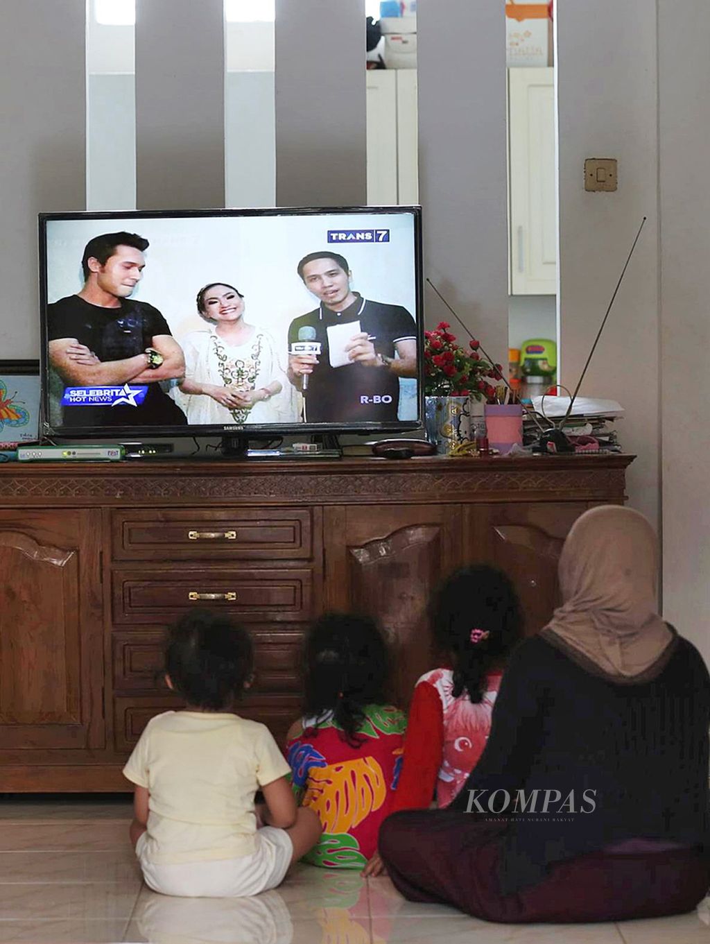 Warga menonton tayangan televisi di rumahnya di Pondok Karya, Tangerang Selatan, Selasa, 23 Juni 2015. 