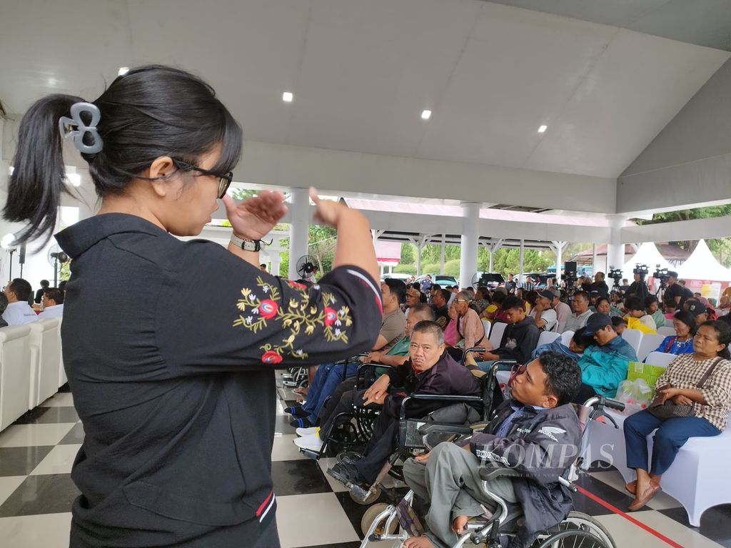 Penerjemah menuturkan bahasa isyarat kepada para peserta dalam acara ”Disabilitas Cakap Keuangan, Keuangan Semakin Inklusif” di Pendopo Kantor Bupati Toba, Sumatera Utara, Jumat (9/8/2024).