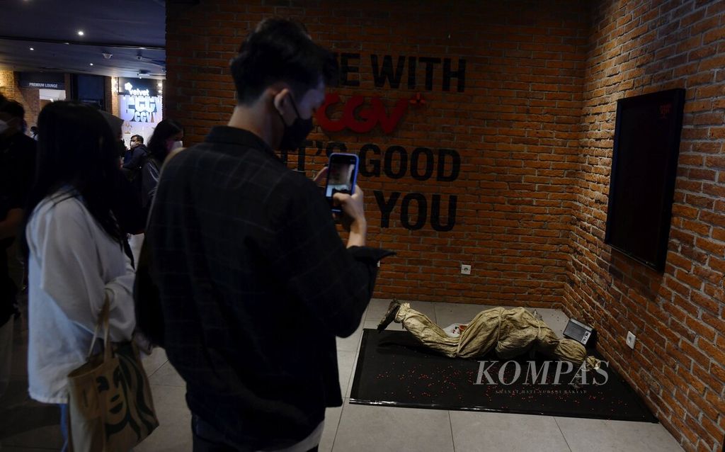 Pengunjung mengambil foto salah satu instalasi sebagai bagian promosi film <i>Pengabdi Setan 2: Communion</i> saat tayang perdana di bioskop CGV Grand Indonesia, Jakarta, Kamis (4/8/2022). 