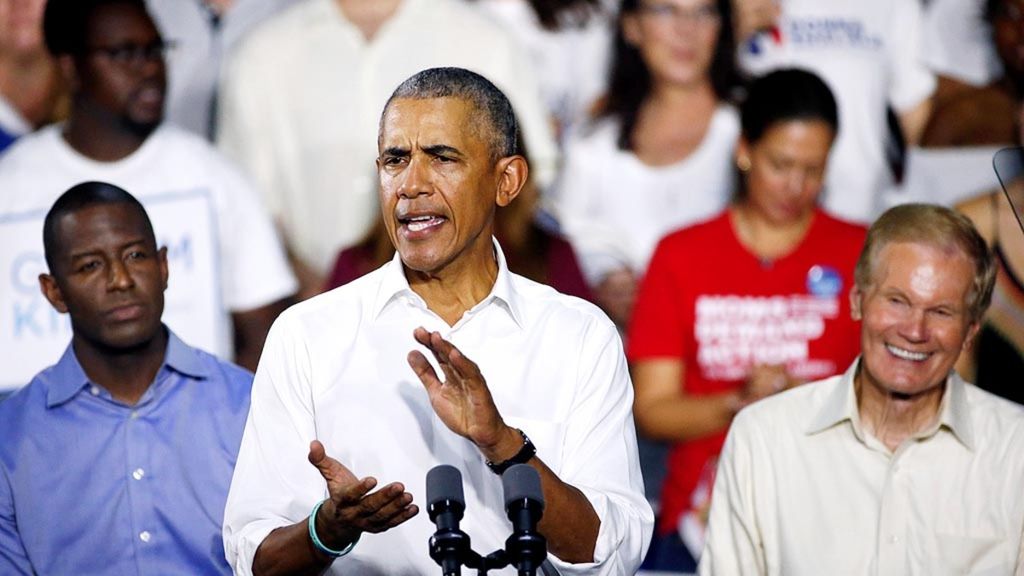 Calon gubernur Negara Bagian Florida, Amerika Serikat, Andrew Gillum, dari Partai Demokrat (kiri) serta Senator Florida Bill Nelson dari Demokrat (kanan) mendengarkan mantan Presiden Barack Obama berbicara kepada media dan pendukung dalam kampanye di Miami, Florida, Jumat (2/11/2018).