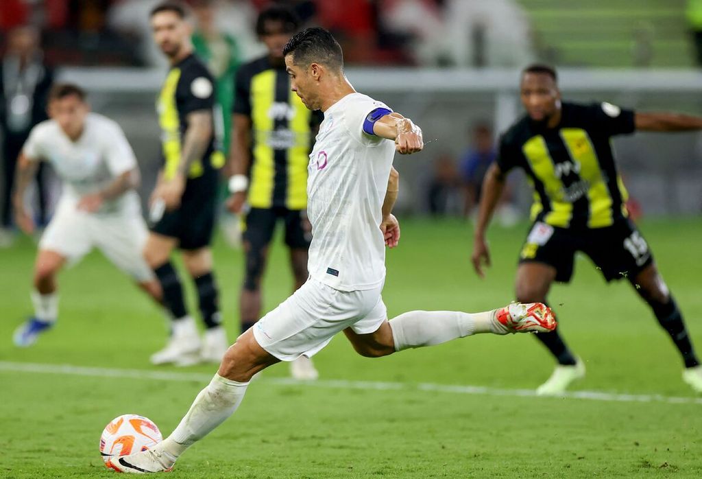 Penyerang Al Nassr, Cristiano Ronaldo, menendang bola saat pertandingan Liga Arab Saudi antara Al Ittihad dan Al Nassr di Stadion Pangeran Abdullah al-Faisal di Jeddah, Selasa (26/12/2023). 