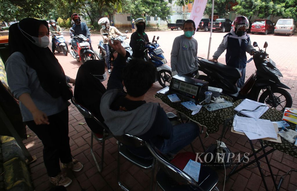 Pengendara motor mengantre uji emisi gratis di halaman GOR Senam DKI Raden Inten, Jakarta Timur, Selasa (29/3/2022).