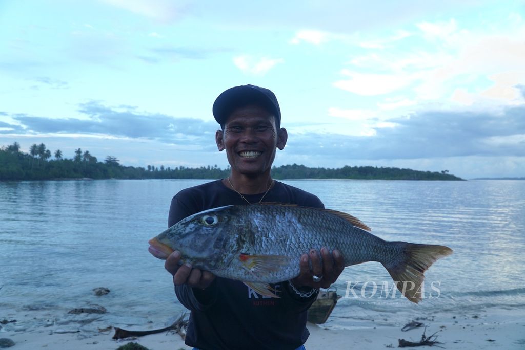 Nelayan berpose dengan ikan hasil tangkapannya di Dusun Sinaka, Desa Sinaka, Kecamatan Pagai Selatan, Kepulauan Mentawai, Sumatera Barat, Senin (19/6/2023). Optimalisasi pemanfaatan potensi kelautan masih menjadi tantangan Sumbar memasuki usianya ke-78 pada 1 Oktober 2023.