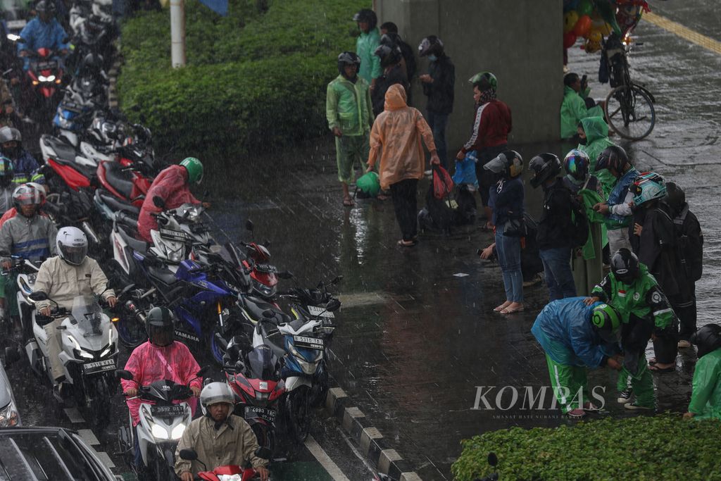 Warga berteduh di Jalan Letjen MT Haryono, Jakarta, Selasa (30/1/2024). BMKG memperingatkan potensi terjadinya hujan ekstrem hingga sepekan ke depan. 