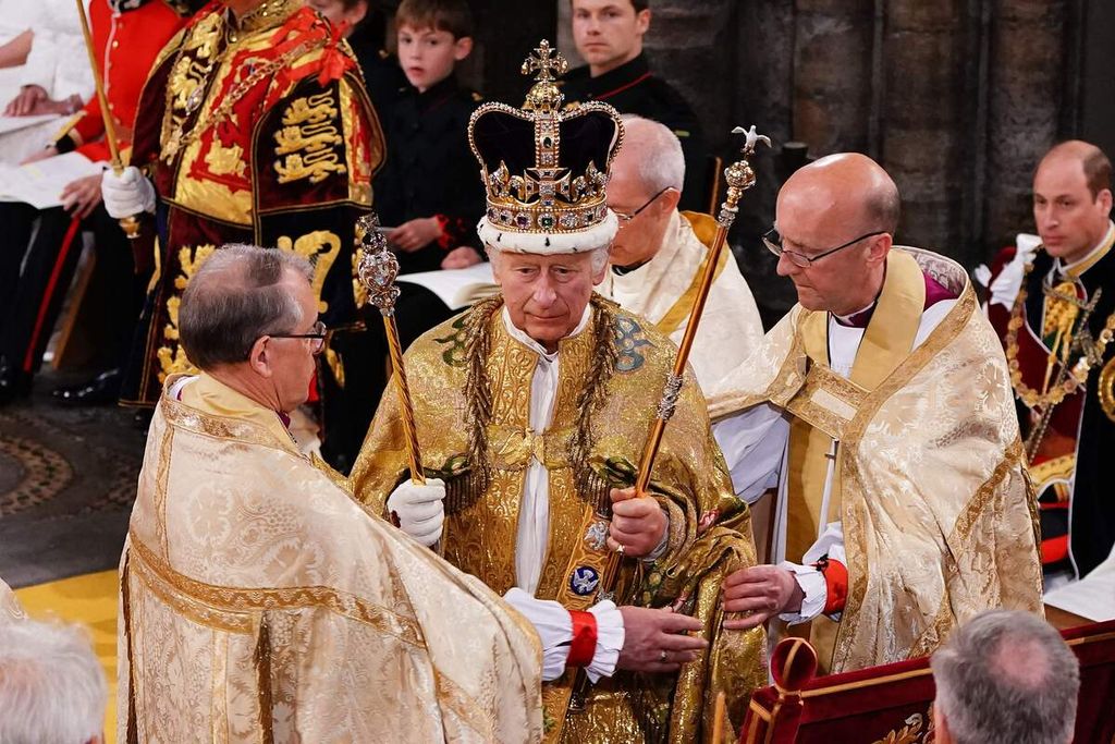 Raja Inggris Charles III (tengah), dengan mengenakan mahkota St Edward di kepala, mengikuti upacara penobatan dirinya di Westminster Abbey, London, Inggris, Sabtu (6/5/2023). 