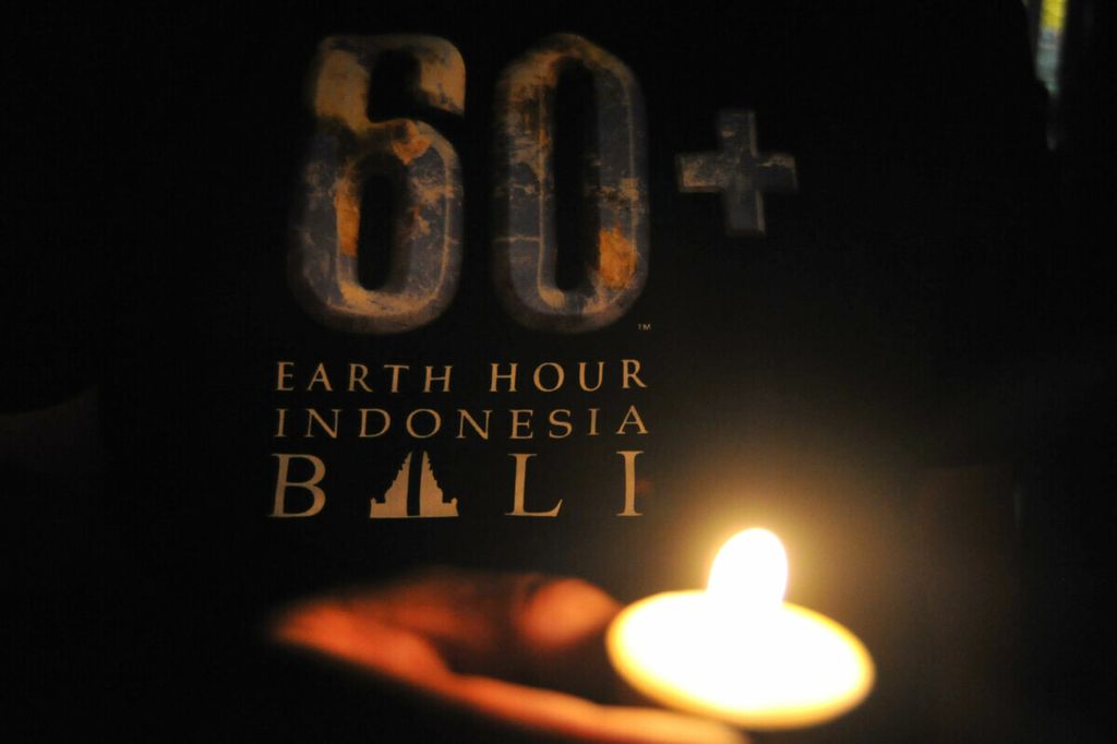 Warga menyalakan lilin saat peringatan Earth Hour di Denpasar, Bali, Sabtu (27/3/2021). 