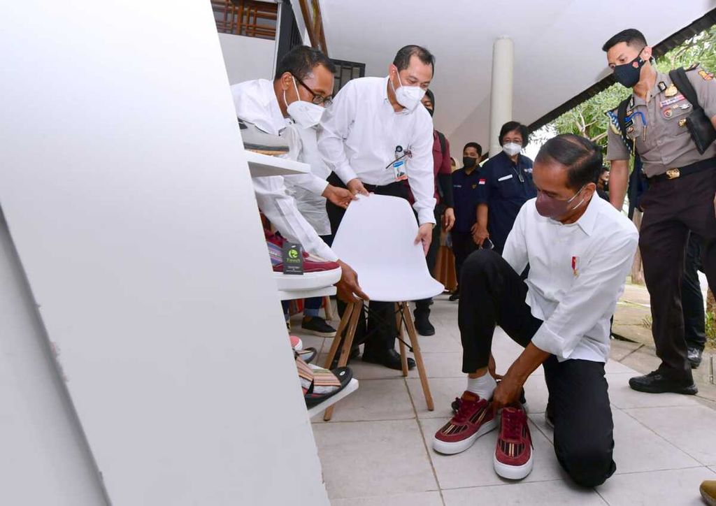 Presiden Joko Widodo mencoba sepatu tenun produksi Sentosa Sasak Tenun dari Pringgasela Lombok Timur dalam kunjungan kerjanya di area Bazzar Mandalika, Kawasan Ekonomi Khusus Mandalika, Kuta, Pujut, Lombok Tengah, Kamis (13/1/2022). Presiden mengaku menyukai produk tersebut dan membeli satu pasang sepatu.