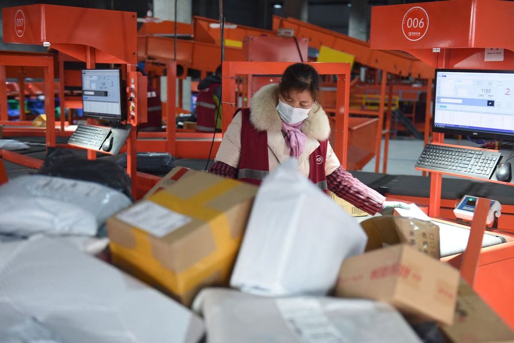 Seorang karyawan menyortir paket-paket kiriman di sebuah pusat logistik di Donghai, Provinsi Jiangsu, China timur, 13 Desember 2022. 