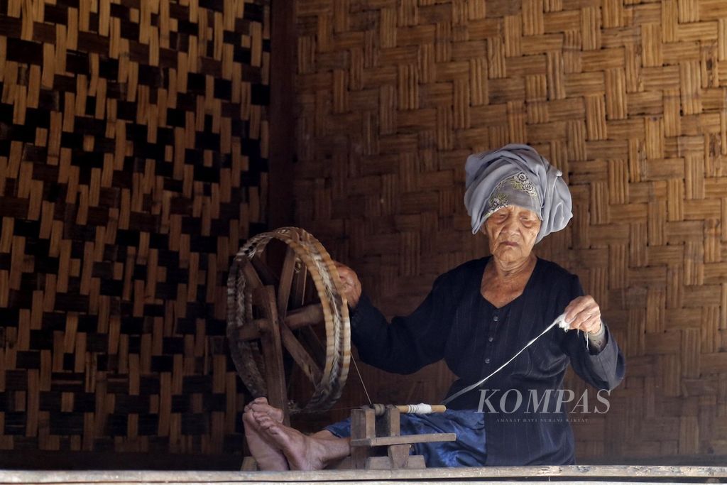 Warga Baduy Luar di Desa Kanekes, Leuwidamar, Lebak, Banten, sedang memintal benang di teras rumahnya, Sabtu (8/7/2023). Selain untuk memenuhi sandangnya, kain tenun yang dihasilkan juga ditawarkan kepada wisatawan yang datang mengunjungi kampung mereka. 