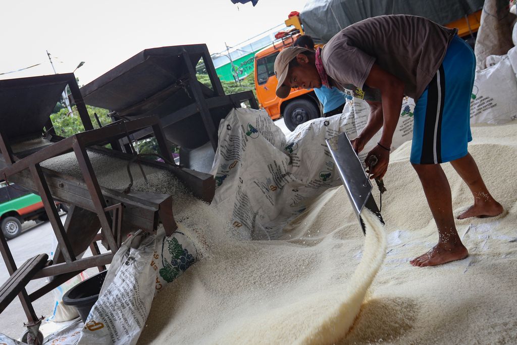 Seorang pekerja mengayak beras di Pasar Induk Beras Cipinang, Jakarta Timur, Rabu (2/11/2022). Food Station mencatat, rata-rata harga beras di Pasar Induk Beras Cipinang terus merangkak naik sejak Juli 2022. Selain itu, BPS juga mencatat kenaikan harga beras pada skala nasional sejak Agustus 2022.