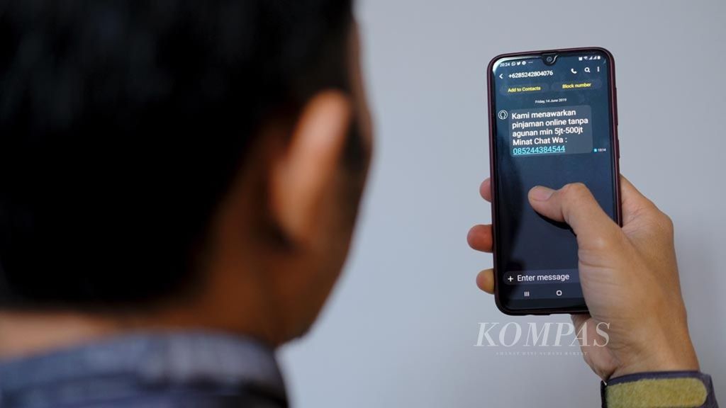 Warga memerlihatkan salah satu pesan singkat yang menawarkan pinjaman berbasis daring, Jakarta, Minggu (16/6/2019).