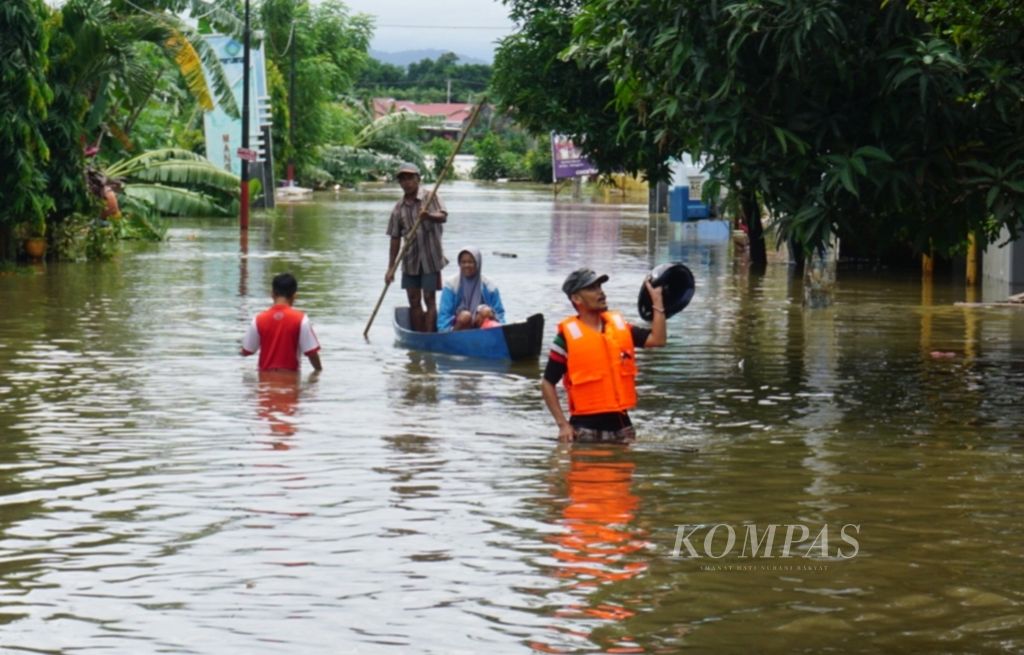 Anggota tim Aksi Cepat Tanggap (ACT) membantu proses evakuasi warga menggunakan perahu dari permukiman yang terendam banjir di Perumnas Antang, Blok 10, Kecamatan Manggala, Makassar, Kamis (24/1/2018).