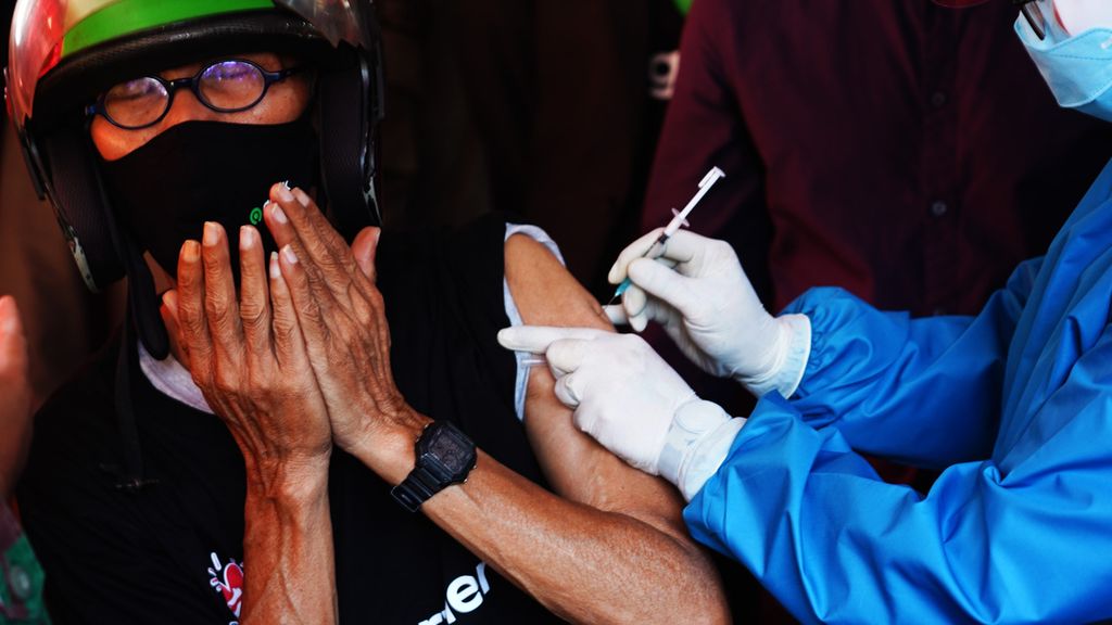 Ekspresi wajah Endang (64), seorang pengemudi ojek daring, saat memperoleh suntikan vaksin dalan layanan vaksinasi kendara lewat bagi warga lanjut usia di GOR Pajajaran, Kota Bogor, Jawa Barat, Rabu (17/3/2021). 