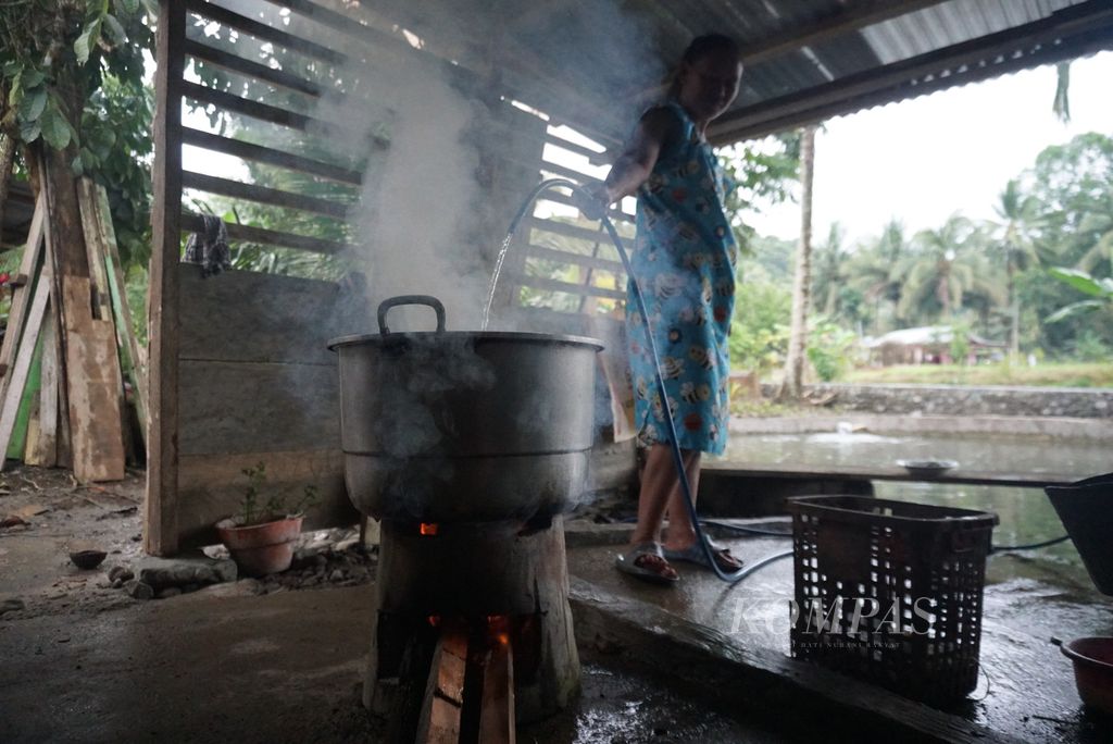 Jelita Makalalag mengisi air kedalam panci untuk memasak di rumahnya yang terletak di Dusun I Desa Mengkang, Kecamatan Lolayan, Bolaang Mongondow, Sulawesi Utara, Jumat (15/7/2022).