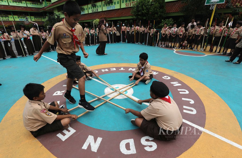 Siswa SDN 07 Ujung Menteng, Jakarta Timur, bermain lompat tongkat saat mengikuti sesi eksul pramuka di halaman sekolah mereka, Rabu (4/1/2023).  