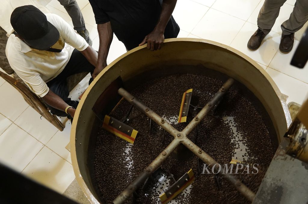 Pengurus koperasi memasukkan biji kopi arabika ke kantong kain usai disangrai  (<i>roasting)</i> di Rumah Kopi Amungme Gold, Timika, Papua, pertengahan Maret 2022. 