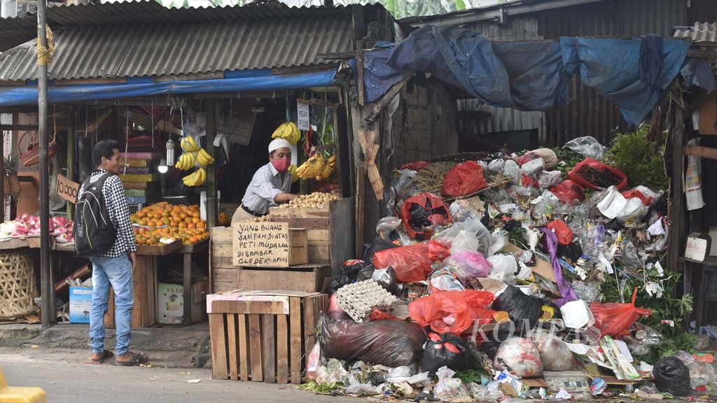 Tumpukan sampah yang berada di samping pedagang buah menjadi salah satu pemandangan kumuh di depan Pasar Kreo, Tangerang, Banten, Senin (22/2/2021). Para pedagang menyampaikan bahwa sampah yang menggunung di tempat tersebut bukan hanya sampah dari pedagang pasar, melainkan juga sampah rumah tangga yang dibuang warga.