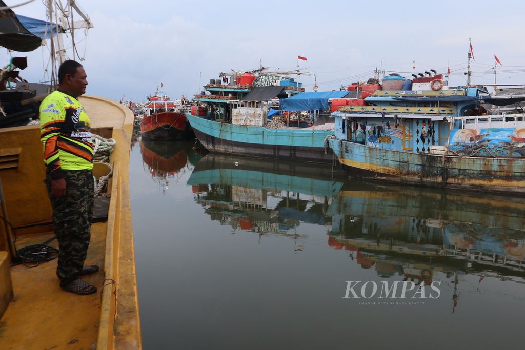 Caswinto, nakhoda KM Anugerah, menunjukkan sejumlah kapal nelayan yang tidak melaut karena masalah bahan bajar minyak di Karangsong, Kabupaten Indramayu, Jawa Barat, Kamis (9/6/2022). 