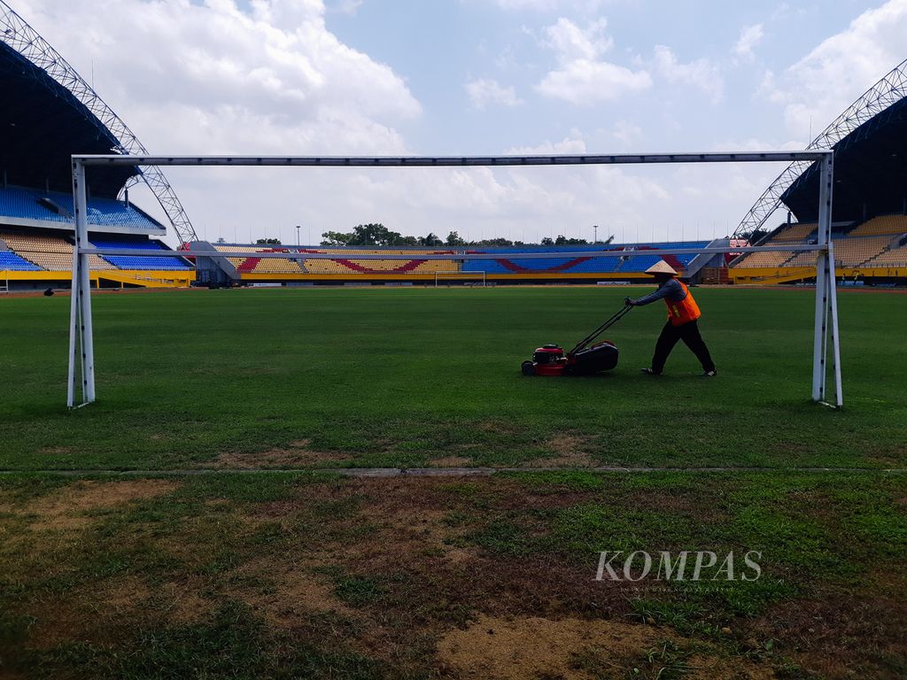 Seorang pekerja tengah memotong rumput Stadion Gelora Sriwijaya yang berada di Kompleks Olahraga Jakabaring, Palembang, Sumatera Selatan, Kamis (27/8/2020). Stadion ini merupakan salah satu stadion yang diajukan ke FIFA untuk dijadikan tempat pertandingan Piala Dunia U-20 pada 2021.