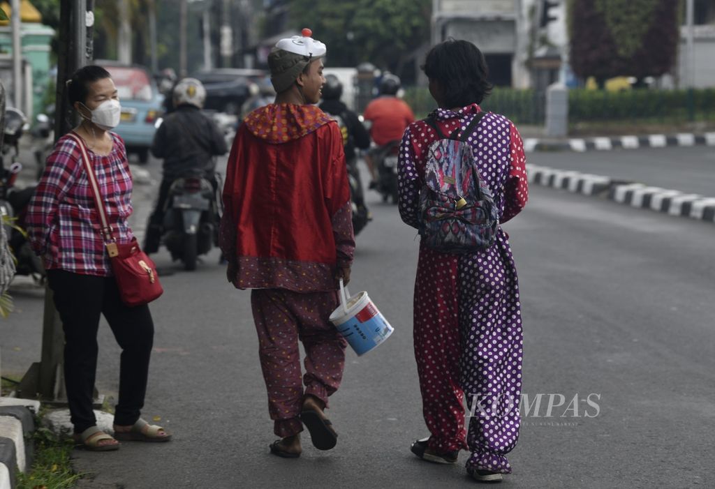 Badut jalanan berkeliling untuk mengamen di kawasan Tanah Abang, Jakarta Pusat, Selasa (21/6/2022). 