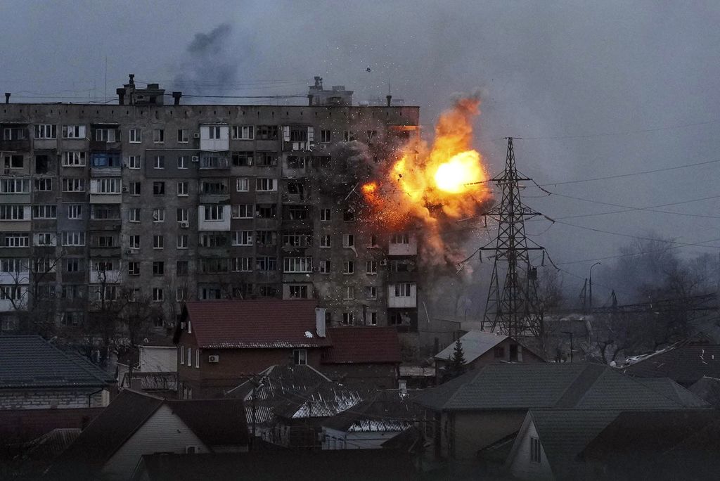 Kobaran api terlihat dari sebuah bangunan yang terkena tembakan artileri berat dari sebuah tank milik militer Rusia di Kota Mariupol, Ukraina, Jumat (11/3/2022). 
