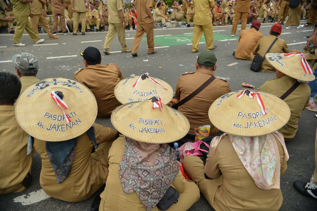 Beberapa kepala desa menggunakan caping untuk melindungi kepala dari sinar matahari saat melakukan unjuk rasa di depan gedung DPR, Jakarta, Selasa (17/1/2022). Ribuan kepala desa yang tergabung ke dalam Perkumpulan Aparatur Pemerintah Desa Seluruh Indonesia (Papdesi) meminta Undang-Undang (UU) Desa direvisi.