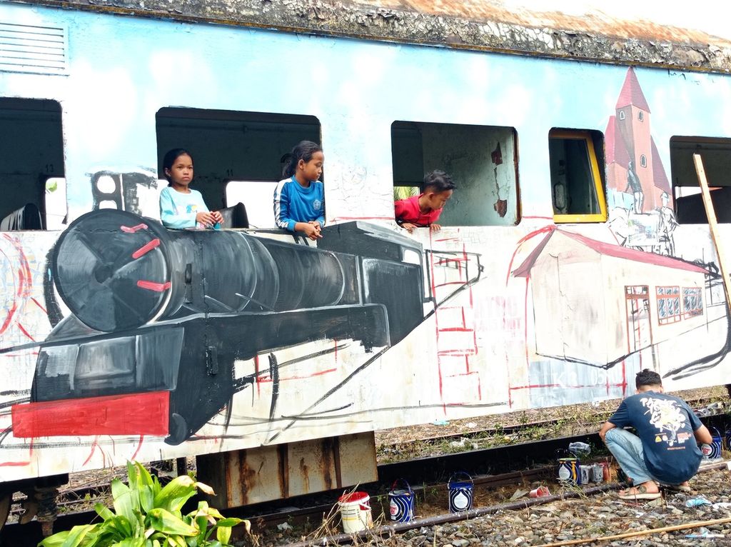 Anak-anak menyaksikan perupa menggambar di gerbong kereta bekas dalam kegiatan Gelanggang Arang yang diadakan di Stasiun Kota Solok, Sumatera Barat, Selasa (12/12/2023). 