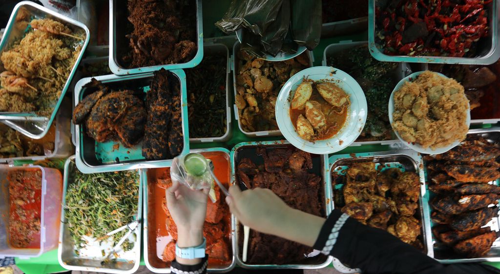 Pedagang makanan takjil berbuka puasa melayani pembeli di Pasar Rawamangun, Jakarta Timur, Selasa (13/4/2021). Pasar takjil ini merupakan salah satu sentra makanan musiman yang ramai dikunjungi warga menjelang berbuka puasa. Pedagang pasar takjil musiman memanfaatkan momen bulan puasa untuk meraup rezeki di tengah pandemi. 
