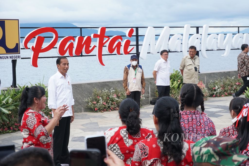 Presiden Joko Widodo menyapa anak-anak SD ketika meresmikan anjungan pantai Manado Beach Walk, Jumat (20/1/2023), di Manado, Sulawesi Utara. Proyek tersebut dibangun dengan anggaran APBN Rp 65,48 miliar selama 2020-2022.