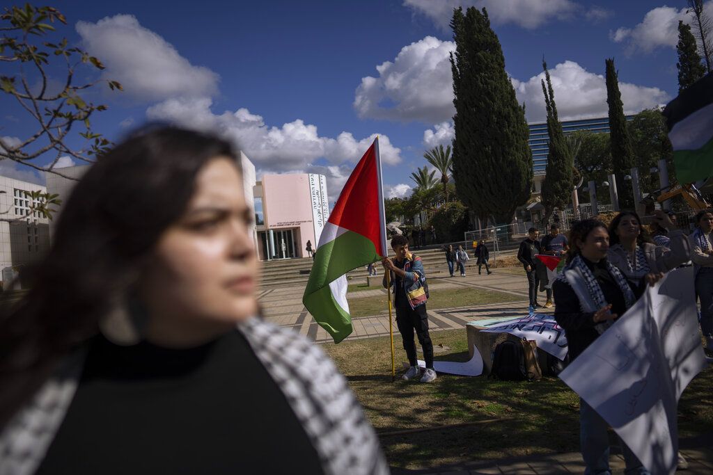 Warga Israel beretnik Palestina, yang meliputi mahasiswa dan aktivis, di Universitas Tel Aviv, Tel Aviv, Israel, Senin (30/1/2023), mengibarkan bendera Palestina dalam unjuk rasa mengecam serangan tentara Israel di Tepi Barat. 