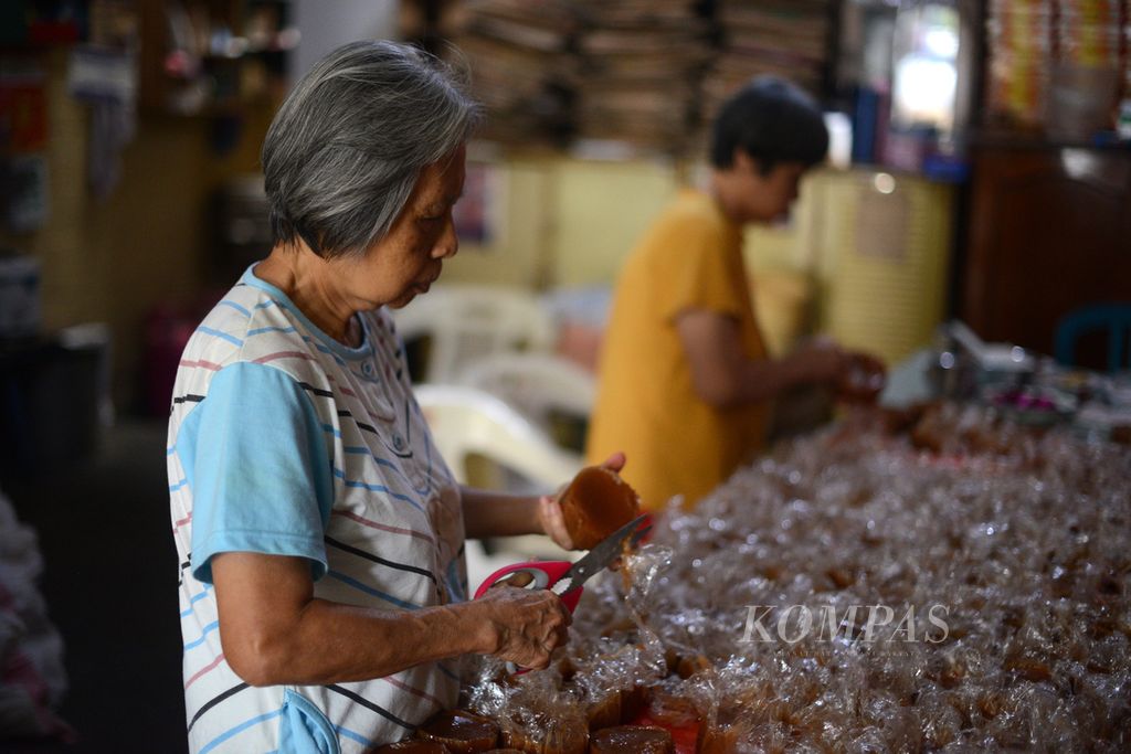 Sianywati (75) dan Sulistyowati (78), kakak beradik, mengemas kue keranjang di tempat usaha milik keluarga mereka di UMKM Bak Cang Kue Mangkuk, Kampung Tukangan, Danurejan, Yogyakarta, Selasa (30/1/2024). 
