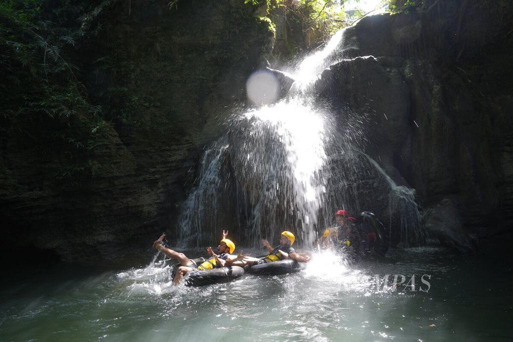 Tourists enjoy the Santirah River Tubing attraction in Selasari Village, Parigi District, Pangandaran Regency, West Java, on Saturday (4/5/2024). The tourism attraction along the 1,500-meter-long Santirah River takes two hours to travel, passing through four caves and five waterfalls. This water tourism was opened in 2014 and is now managed by a village-owned enterprise (BUMDes).
