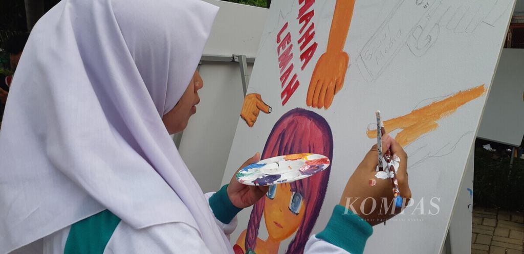 Seorang pelajar tengah menyelesaikan lukisan tentang stop perundungan pada anak di RPTRA Cengkareng Utama, Jakarta Barat, Rabu (26/6/2019) pagi.