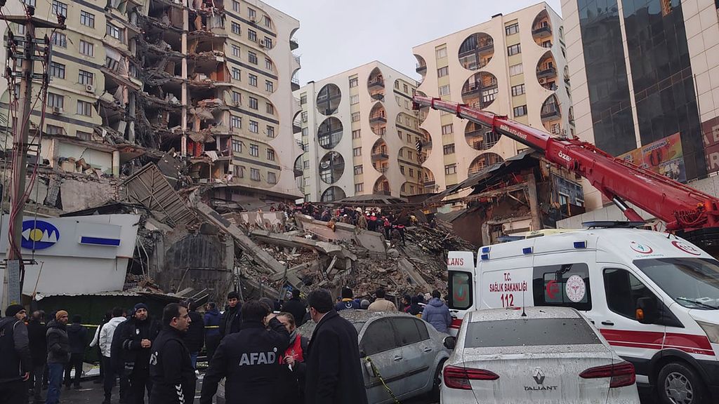 Petugas penyelamat dan tim medis berusaha menemukan warga yang terjebak di bangunan yang runtuh setelah gempa bumi di Diyarbakir, Turki, Senin (6/2/2023).