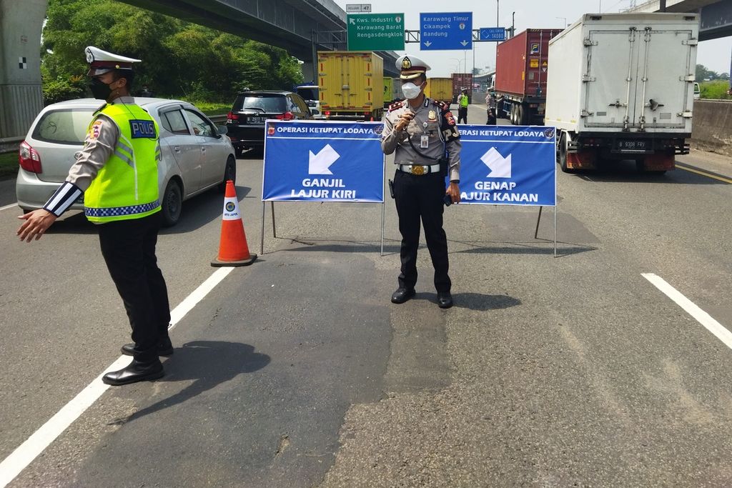 Petugas polisi mengatur lalu lintas dan memisahkan kendaraan berdasarkan aturan ganjil-genap, Selasa (26/4/2022). 