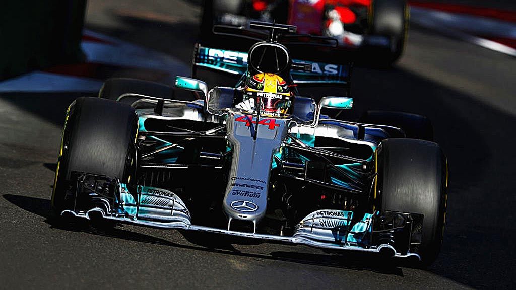 Pebalap  Inggris Raya, Lewis Hamilton,  mengendarai  Mercedes F1 WO8  di depan pebalap Jerman, Sebastian Vettel, yang mengendarai Scuderia Ferrari SF70H, dalam balapan F1 Grand Prix Azerbaijan di Sirkuit  Baku, Minggu (25/6). 