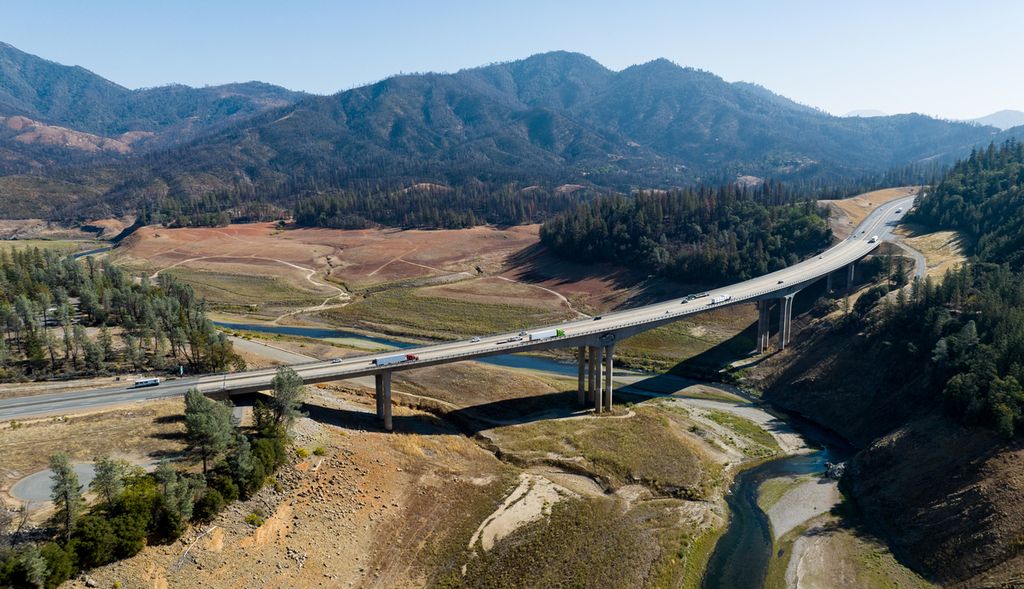 Kendaraan berjalan di sepanjang Interstate 5 di atas sebagian besar Danau Shasta yang kering di Lakehead, California, Amerika Serikat, Minggu (16/10/2022). Kekeringan ekstrem akibat krisis iklim tersebut membuat masyarakat California diwajibkan menghemat penggunaan air.