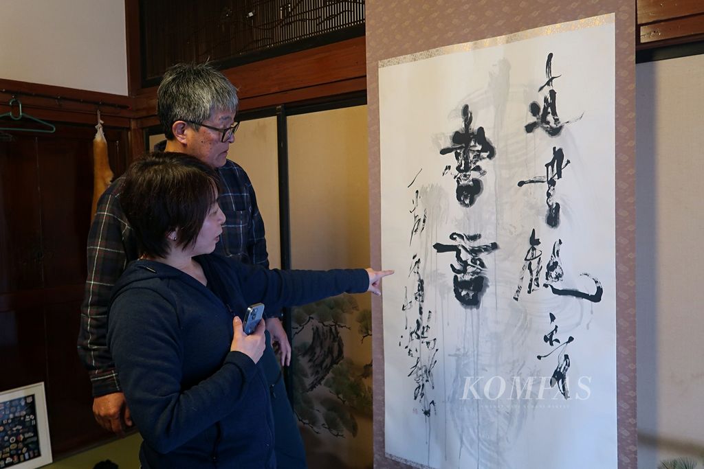 Warga Desa Hakuba, Tadaaki Matsuzawa (63), dan istrinya, Mika Matsuzawa (52), menunjukkan hiasan rumah dalam bentuk kaligrafi yang terpasang di rumah mereka yang berusia 200 tahun lebih di Nagano, Jepang, Minggu (19/2/2023).