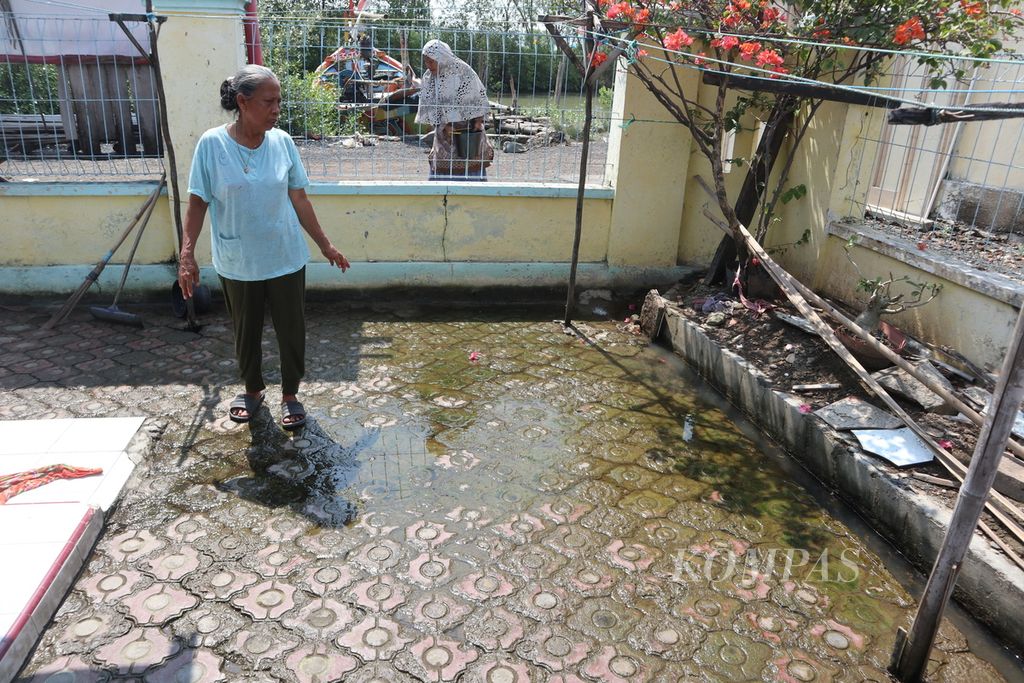 Nuramah (66) menutup saluran drainase untuk mencegah air masuk rumahnya di Blok Balong, Desa Gebang Ilir, Kecamatan Gebang, Kabupaten Cirebon, Jawa Barat, Senin (20/6/2022).