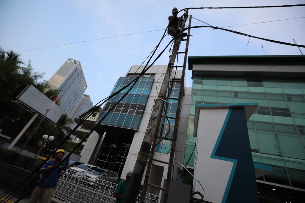Petugas Perusahaan Listrik Negara (PLN) memotong sisa kabel listrik yang tidak berfungsi karena telah dialihkan ke aliran bawah tanah di kawasan Cikini, Jakarta Pusat, Minggu (3/11/2019). 