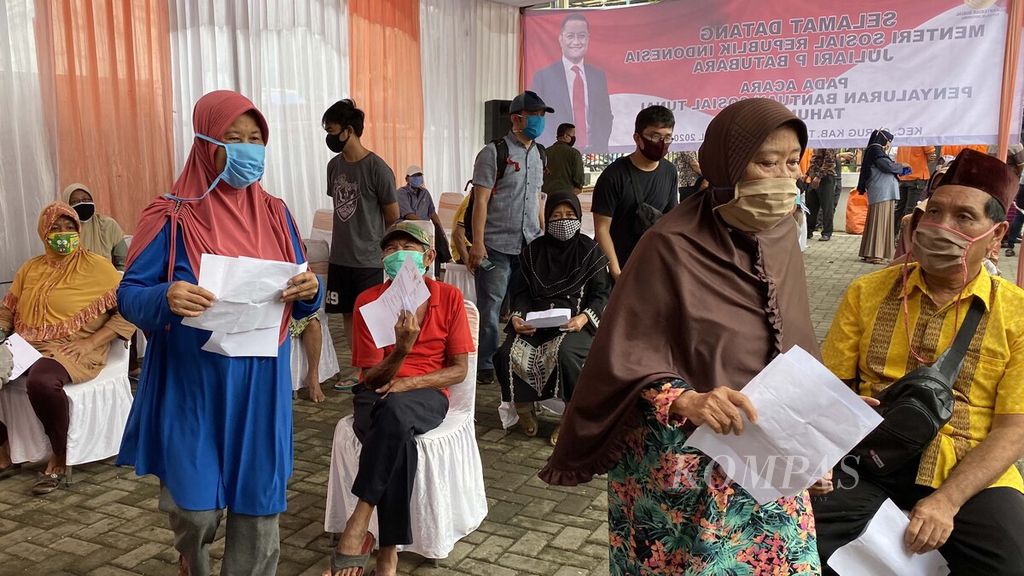 Warga antre untuk mencairkan Bantuan Sosial Tunai di Kantor Pos Kecamatan Curug, Kabupaten Tangerang, Banten, Sabtu (25/4/2020). 