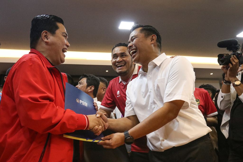 Menteri BUMN Erick Thohir (kiri) menerima bukti pendaftaran calon ketua umum PSSI periode 2023-2027 dari panitia di Kantor PSSI, GBK Arena, Jakarta, Minggu (15/1/2023). 