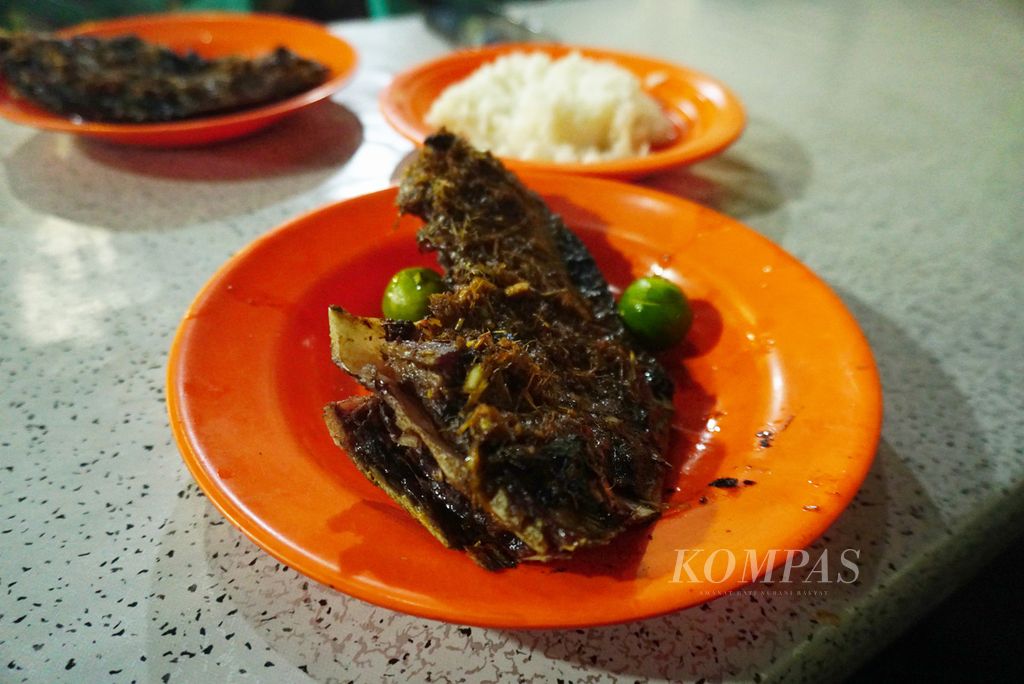 Rahang tuna bakar di Rumah Makan Chit Chat, Manado, Sulawesi Utara, Sabtu (9/12/2023). Makanan tersebut dihidangkan dengan nasi atau singkong rebus, cah kangkung, serta dua macam sambal alias rica, yakni dabu-dabu dan rica bakar.
