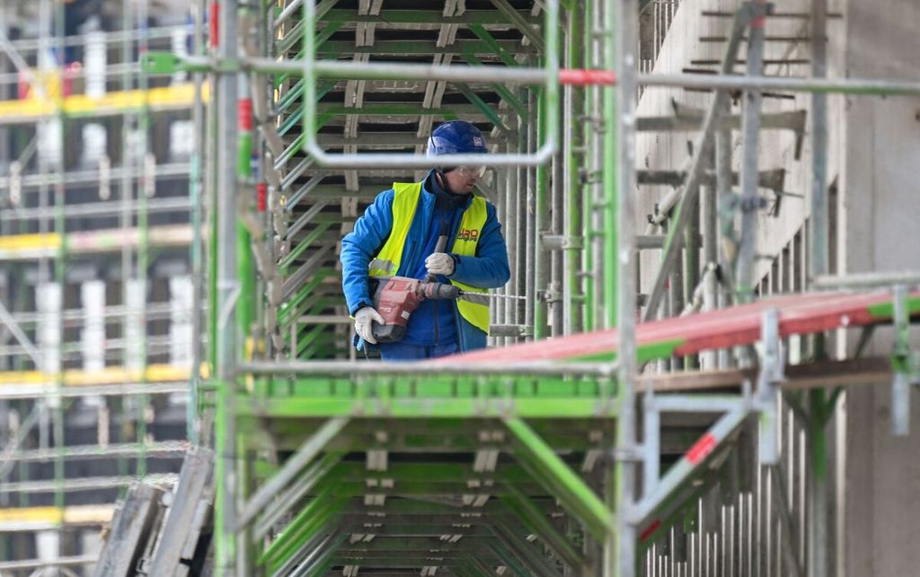 Seorang pekerja konstruksi tengah bersiap bekerja di proyek perkantoran baru di kawasan industri Phoenix West di Dortmund, Jerman pada 5 April 2023.