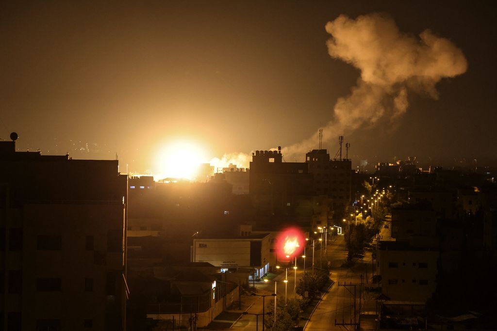 Bola api dan asap mengepul di atas sebuah bangunan di Kota Gaza setelah militer Israel meluncurkan roket ke wilayah tersebut, Jumat (27/1/2023) pagi. 