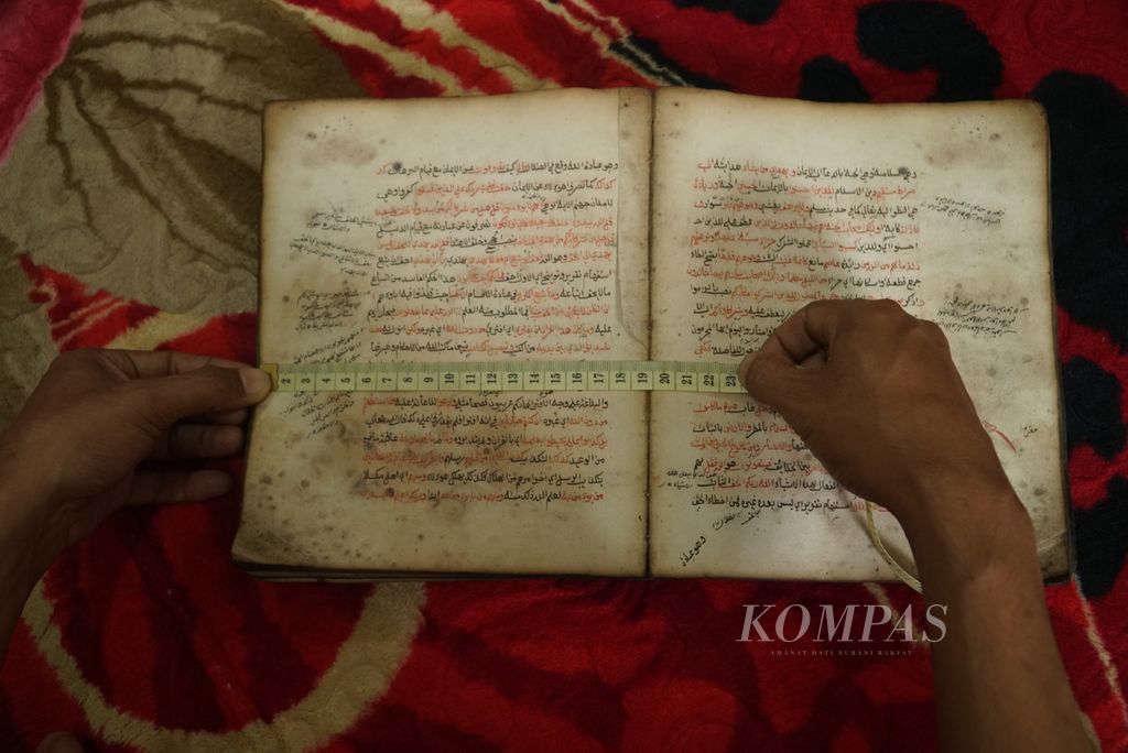 Pegiat konservasi naskah kuno mengukur lebar manuskrip peninggalan Syekh Abdul Latif Syakur (1882-1963) asal Nagari Balai Gurah, Agam, dalam proses didigitalisasi di Padang, Sumatera Barat, Selasa (18/7/2023).