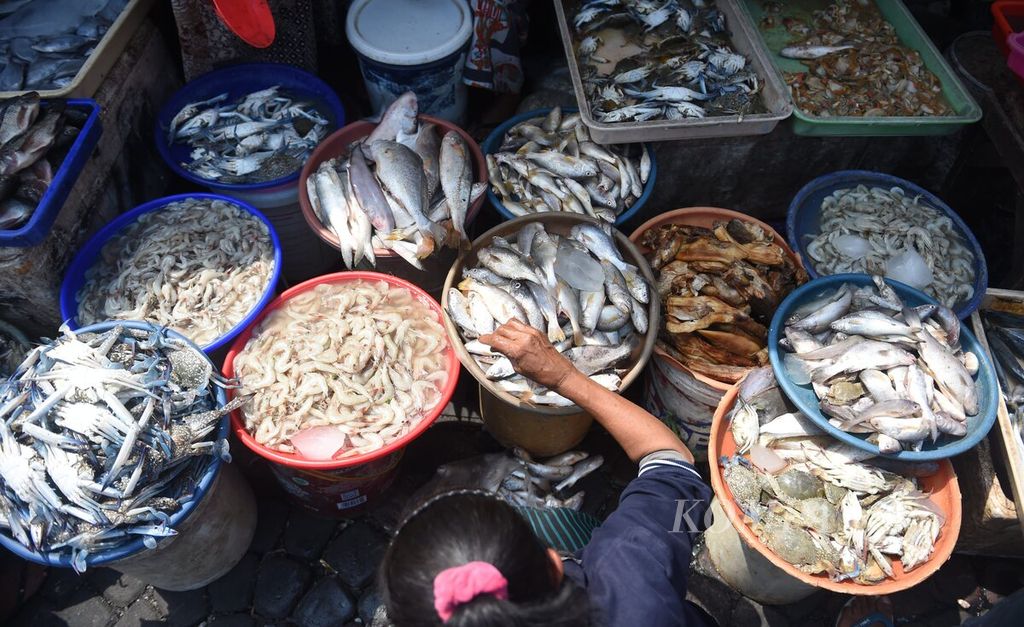 Pedagang merapikan ikan dagangannya di Pasar Ikan Pabean, Surabaya, Kamis (5/1/2023). Banyaknya nelayan yang berhenti melaut akibat cuaca buruk membuat pasokan di Pasar Ikan Pabean terganggu. 