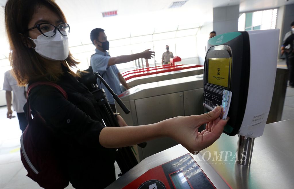 Rombongan jurnalis menempelkan kartu Jaklingko pada mesin pemindai di Stasiun LRT Velodrome, Jakarta Timur, saat turut dalam uji coba penggunaan kartu Jaklingko untuk empat jenis moda transportasi publik, Senin (4/10/2021). 
